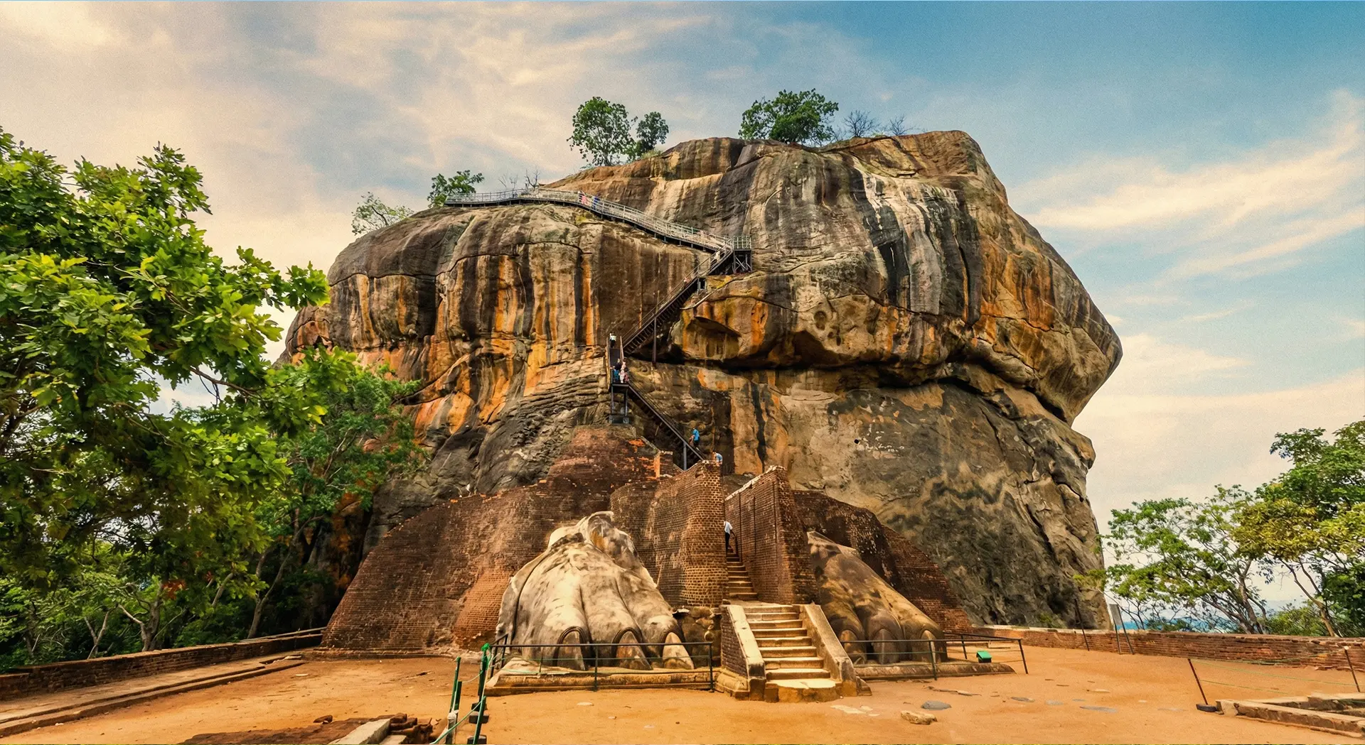 Visitors approaching Sigiriya Rock Fortress through the landscaped water gardens, part of the heritage site.